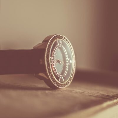 Elegant vintage wristwatch with ornate design, resting gently on a wooden surface, captured in soft focus.