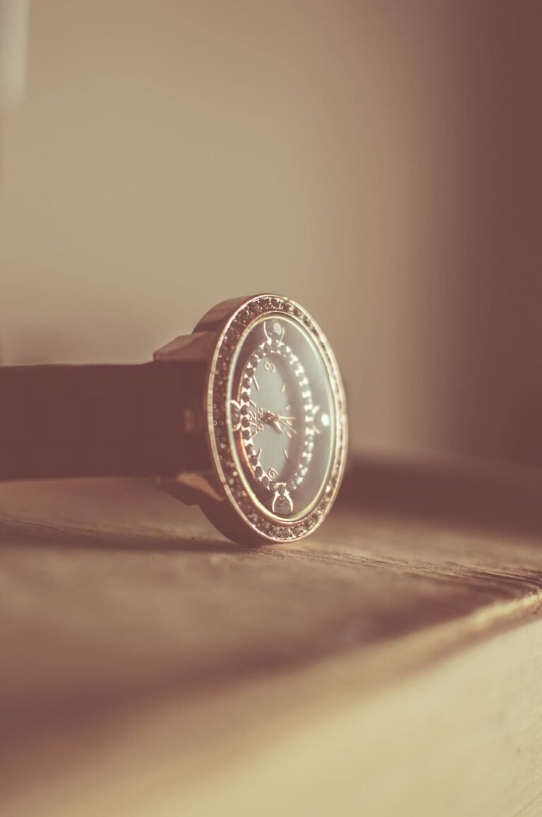 Elegant vintage wristwatch with ornate design, resting gently on a wooden surface, captured in soft focus.